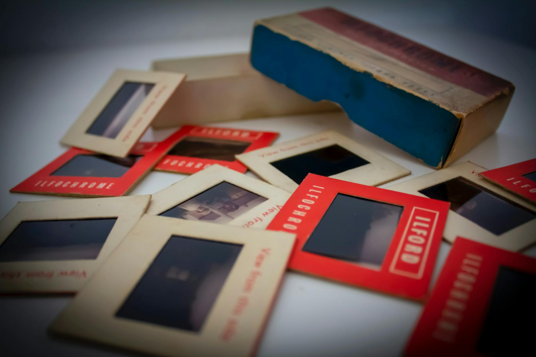 Collection of vintage photo slides and a retro cardboard box showcasing nostalgic imagery.